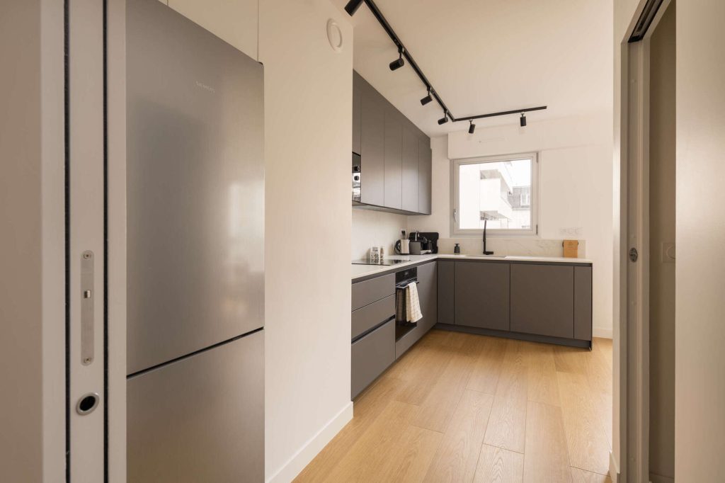 Cuisine rénovée haut de gamme avec mobilier sur mesure et plan de travail contemporain à Strasbourg Neudorf.