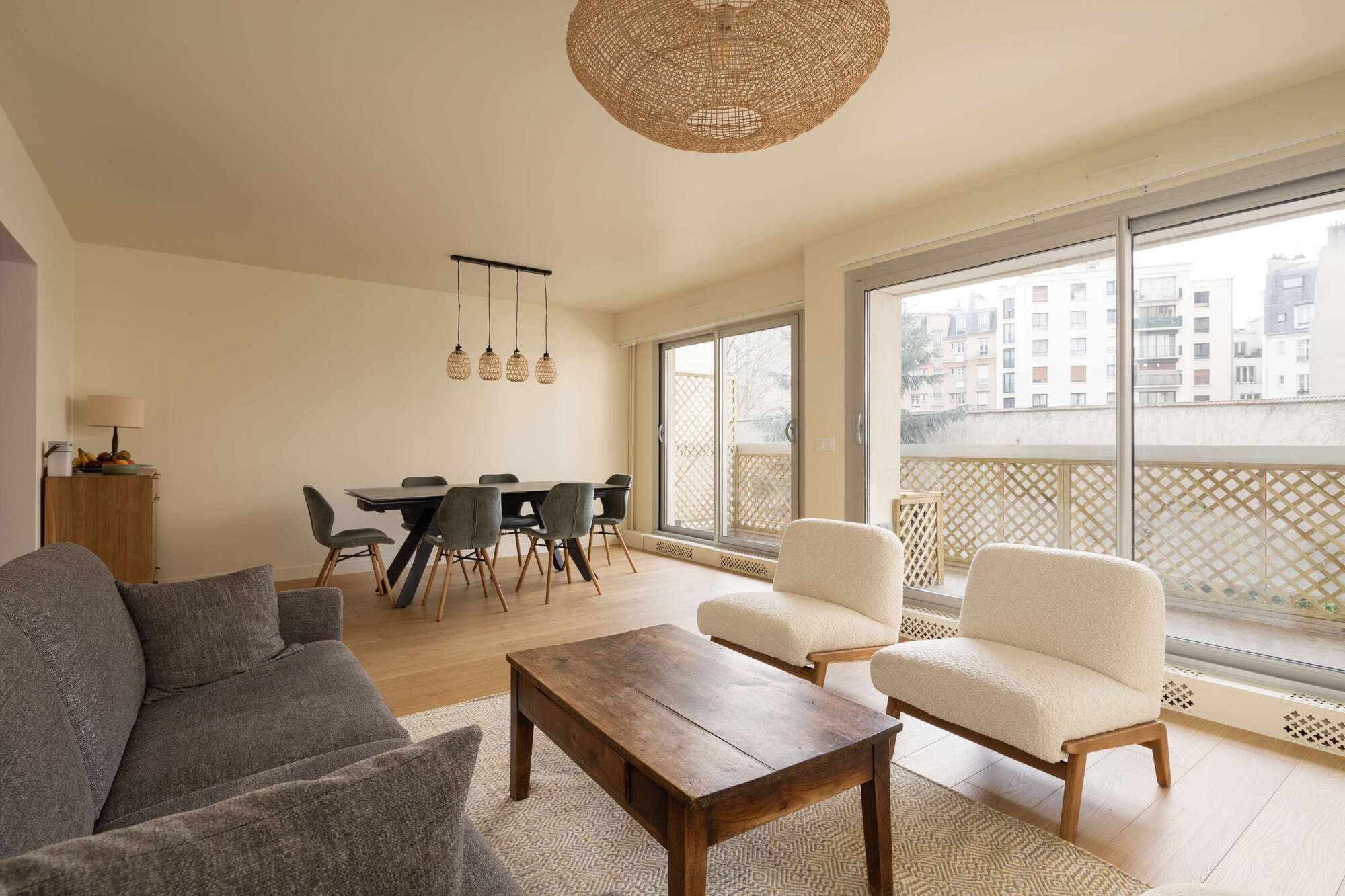 Salon rénové avec parquet, finitions murales soignées et aménagement lumineux.